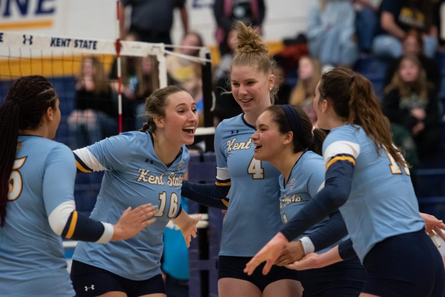 The Kent State volleyball team celebrates after winning a rally.