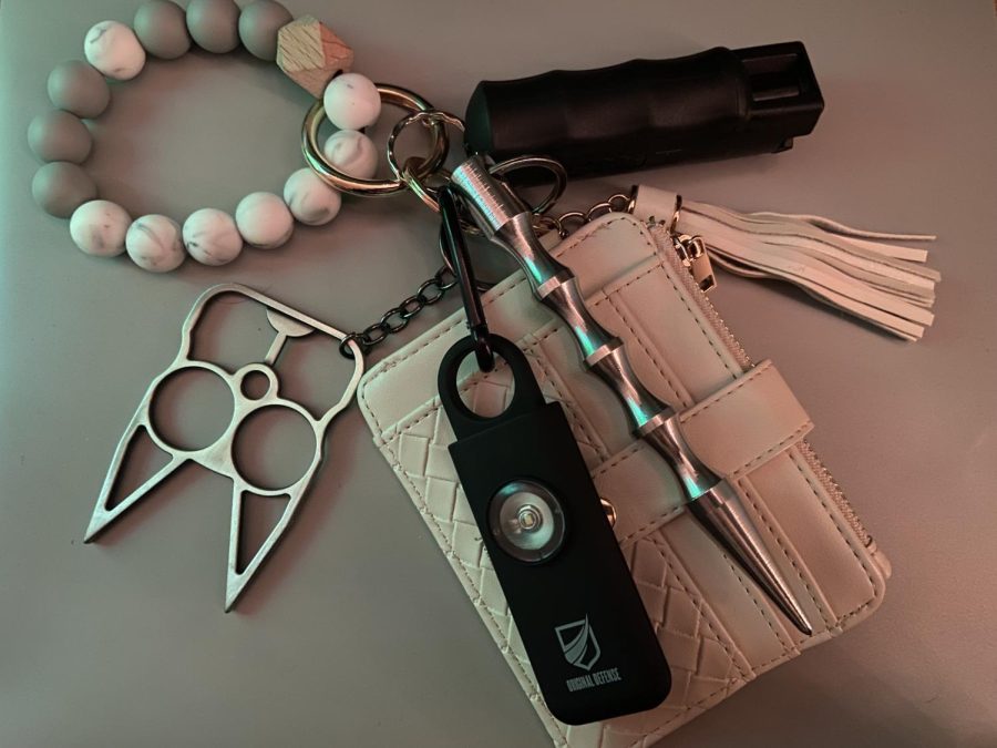 My keychain, featuring my wallet and a variety of self-defense tools: cat-shaped "brass knuckles," a self-defense alarm, a blunt object and pepper spray.