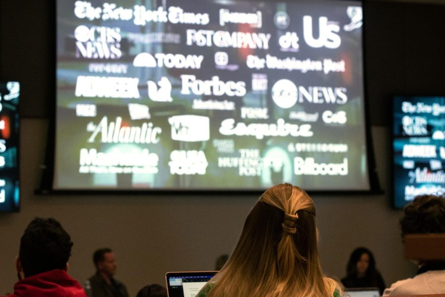 The audience watches as CrossCountry Mortgage's Eric Wilson presents a video detailing his previous work with Chipotle and the game Chipotle Scarecrow during the Faces Behind the Brand event on Nov. 1, 2022.