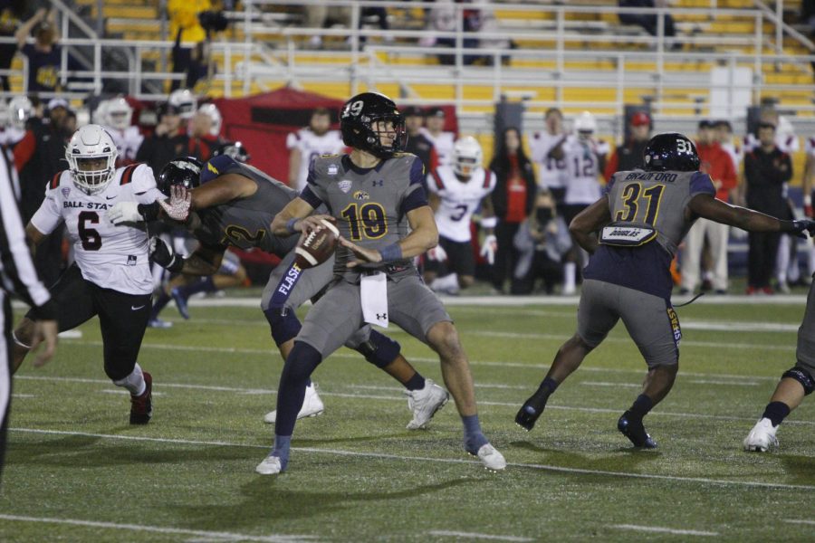 Kent State redshirt junior Collin Schlee scans the field for an open player to throw the ball to as Ball State closes in during the game on Nov. 2.