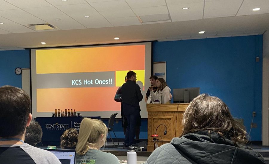 Students gather while professors get ready to eat Hot Wings during a Q&A.