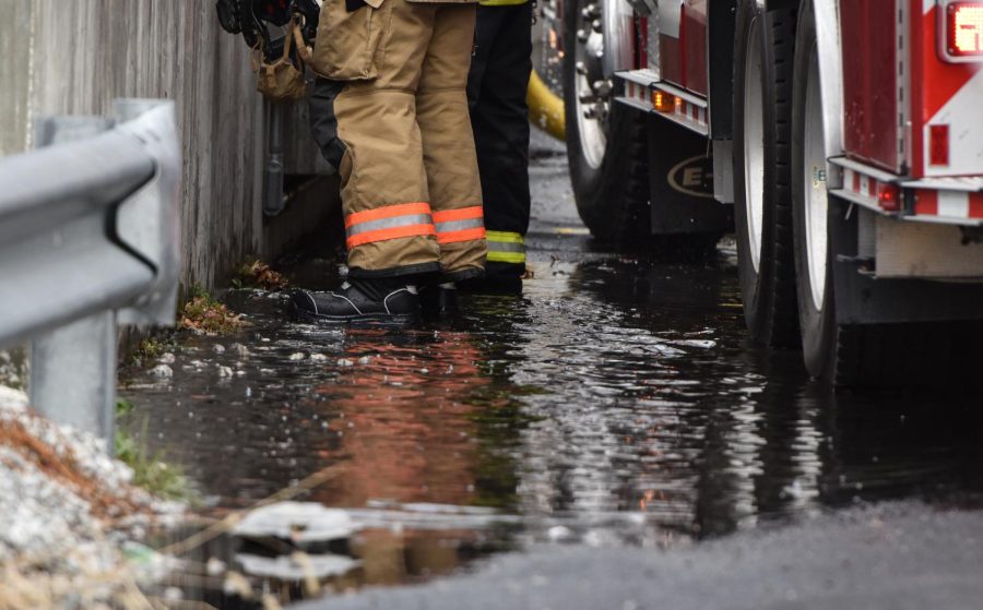 Run-off water from fire hoses pools under the firefighter's feet as they fight the fire at the Star of the West Mill.