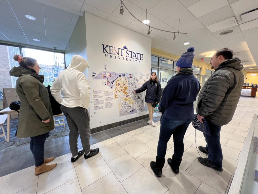 Student tour guide Hannah Hapanowicz points out key buildings on campus to prospective students in the library.