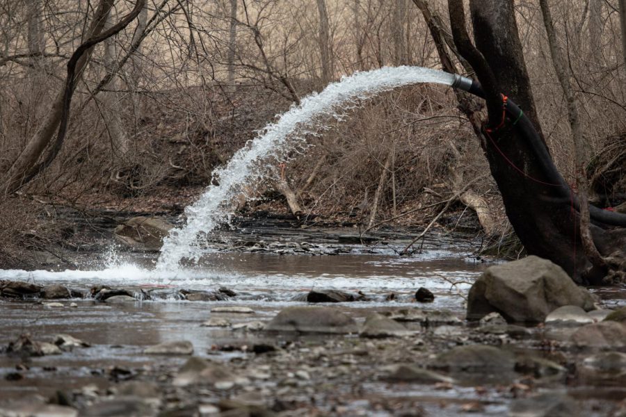 A pump sucks in and sprays water at Leslie Run Creek just ahead of filters set up to catch chemicals in East Palestine, Ohio on Feb. 19, 2023.