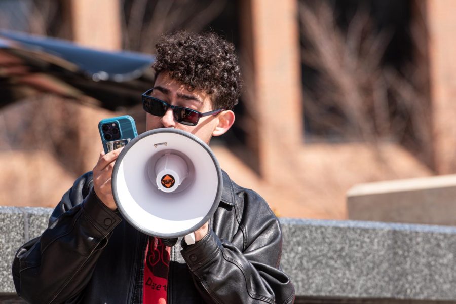 With a microphone in hand, Kent State junior Christian Heller speaks to a gathered audience about women's rights during the SDS speak-out March 8, 2023.