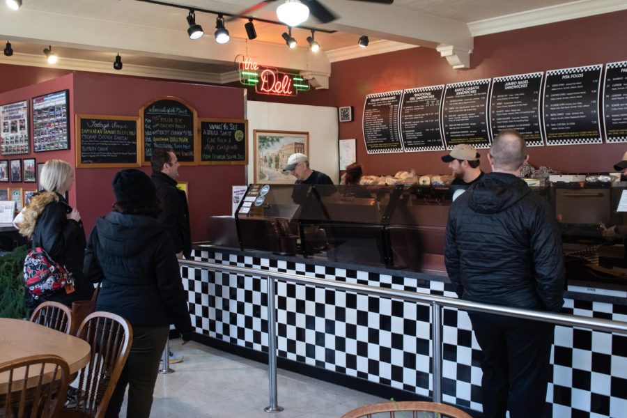 Franklin Deli Owner Carl Picelle and other members of his staff work behind the counter to prepare meals for customers March 15. Franklin Square Deli is located at 108 S. Water St.