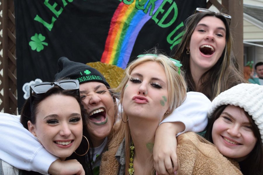 Kent State University students pose in front of a backdrop on the deck of a fraternity during a Fake Paddy's party March 11, 2023.