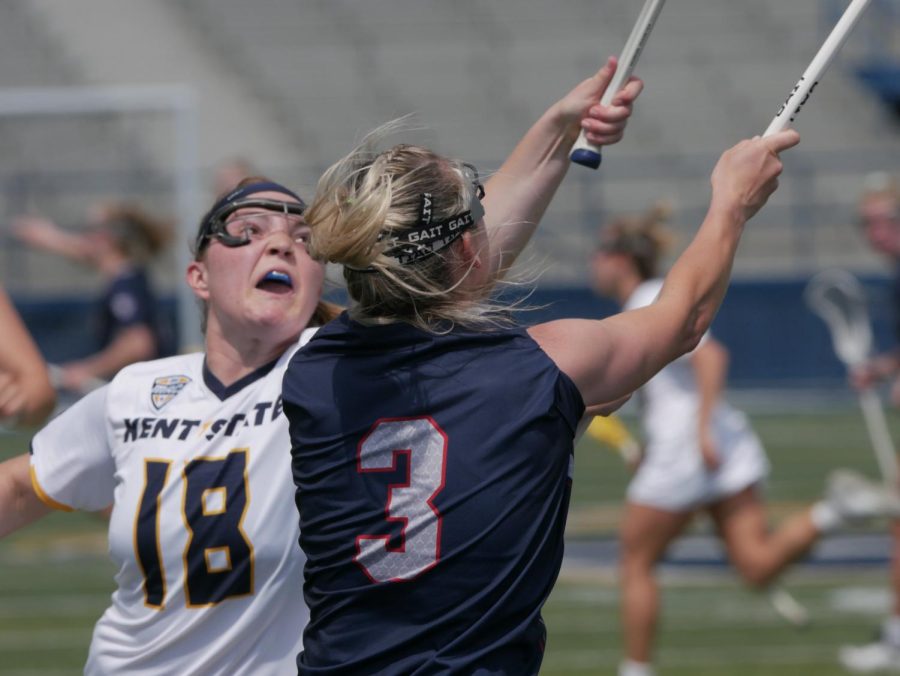 Jackie Wolford (left) tries to block a pass from Kelsey Nelson (center) at Kent State's game against Robert Morris University Apr. 15.