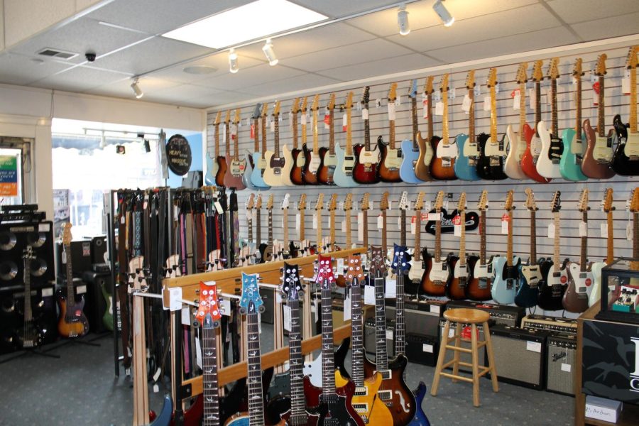 Electric guitars for sale display inside Woodsy's music store.