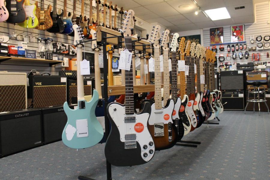 Electric guitars for sale display inside Woodsy's music store.