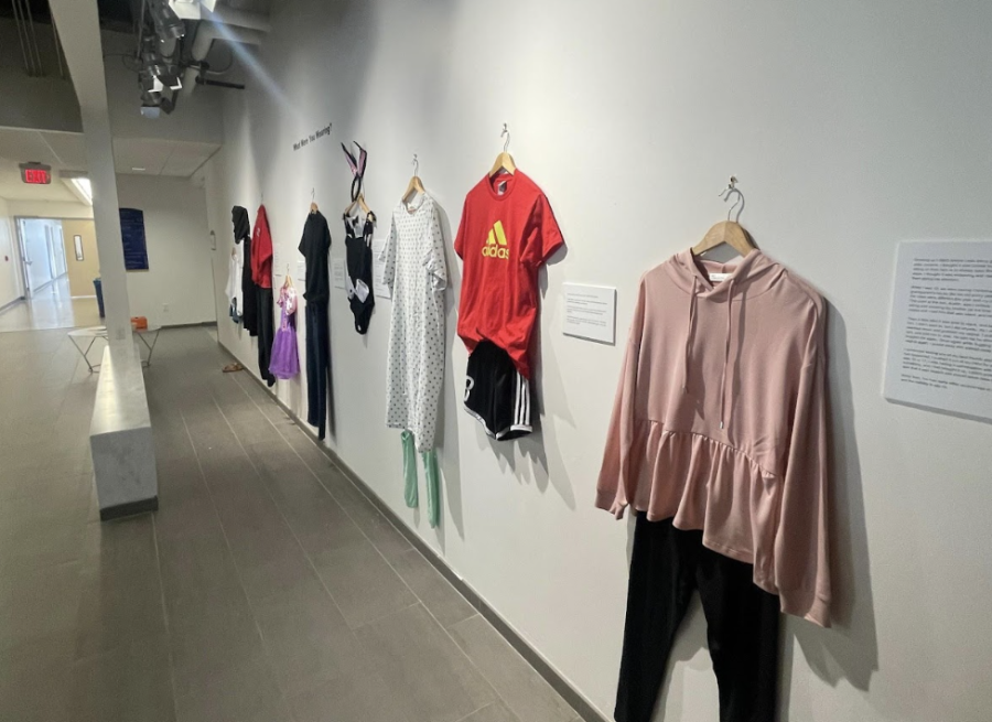 Recreated outfits line the wall at an art installation in the Center for Visual Arts. The "What Were You Wearing" exhibit will be on display through April 14, 2023.