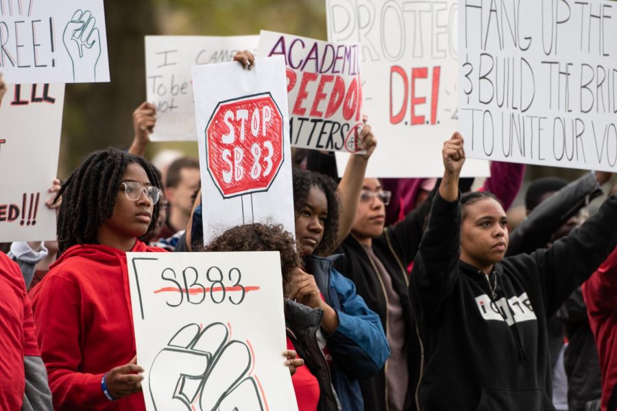 As President Todd Diacon delivers his remarks during the 2023 May 4th Commemoration, silent protestors in opposition to Ohio Senate Bill 83 rose from their seats and stepped forward with signs in hand.