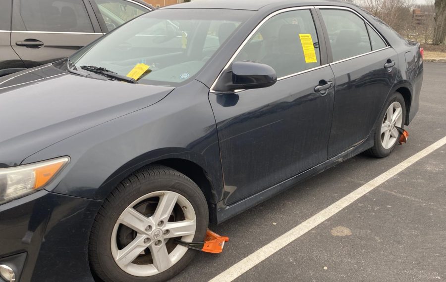 A car parked in the R-3 lot near Taylor Hall has two boots and is plastered with tickets on February 14, 2023. According to Kent State's Parking and Transit Services, a car that has been issued nine or more tickets is at risk of booting or towing.