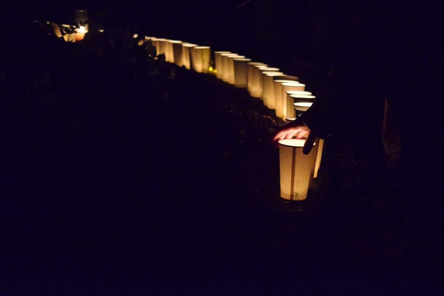 A Candle Vigil attendee places her candle with the rest after the walk May 3, 2023.