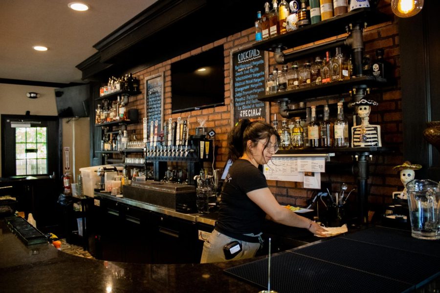 Elizabeth, an employee of The Battleground, wipes down the bar. The Battleground is a Mexican restaurant and social justice taproom.