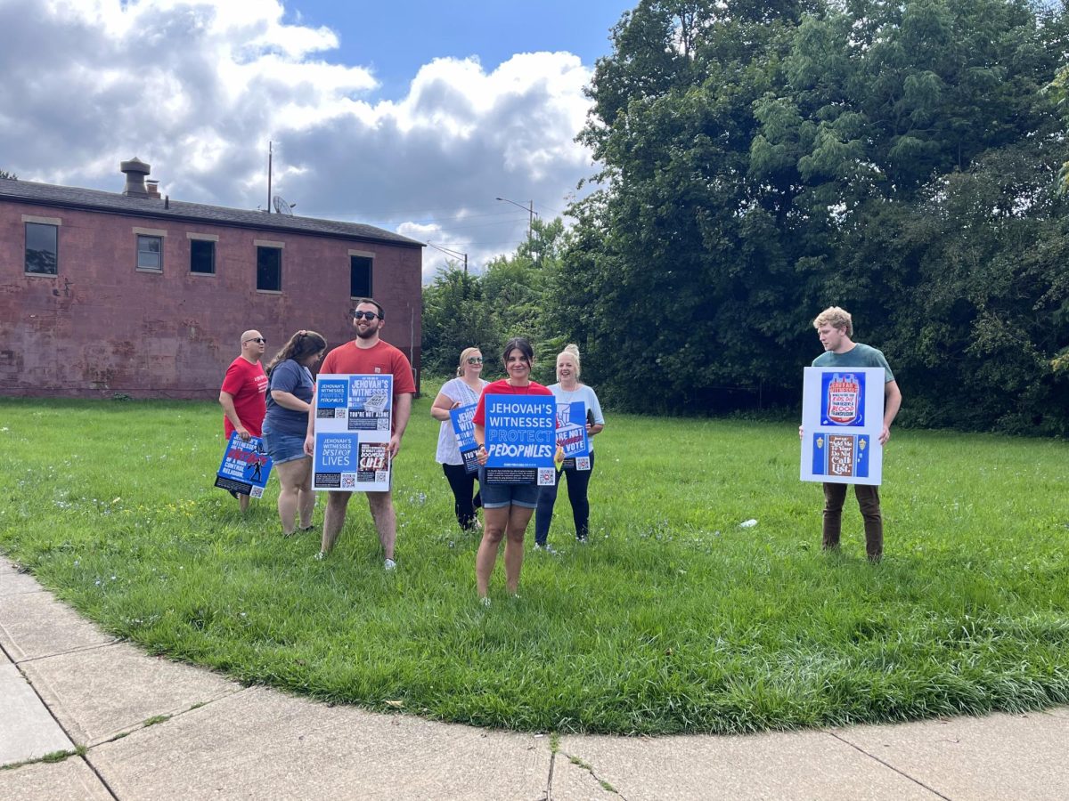 Protestors demonstrate by the farmer's market downtown Saturday.