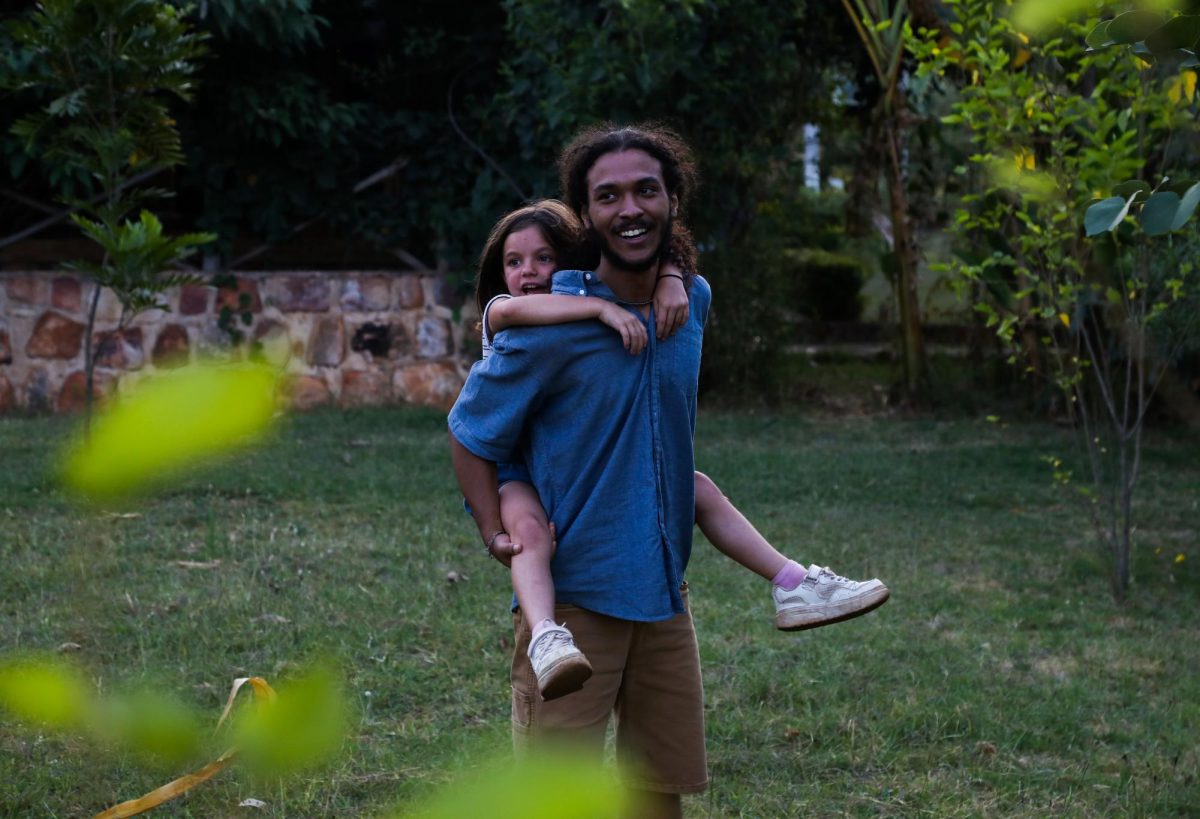 Kaleb Bowen, Kent State Criminology student, carries Sarah Schmidt’s daughter, Salara, on his back while running around and laughing at the lodge in Akagera.