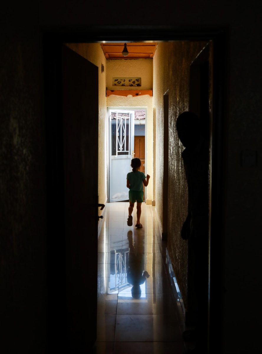 Salara, Sarah Schmidt’s daughter, runs down the hall of Pacifique’s house to his kitchen to get drinks for everyone in the living room and help with dinner.