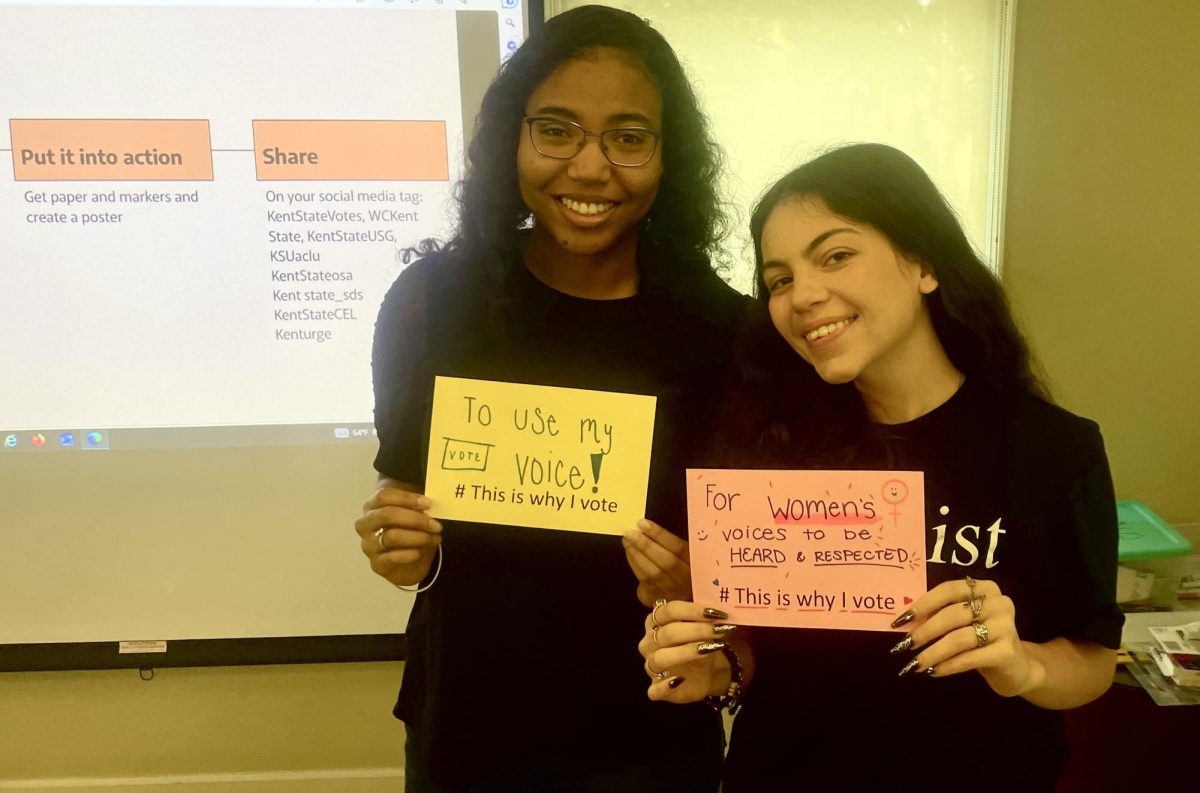 The Women's Center's Hannah Toth and Sarah Robinson make signs at Gather and Give Back event.