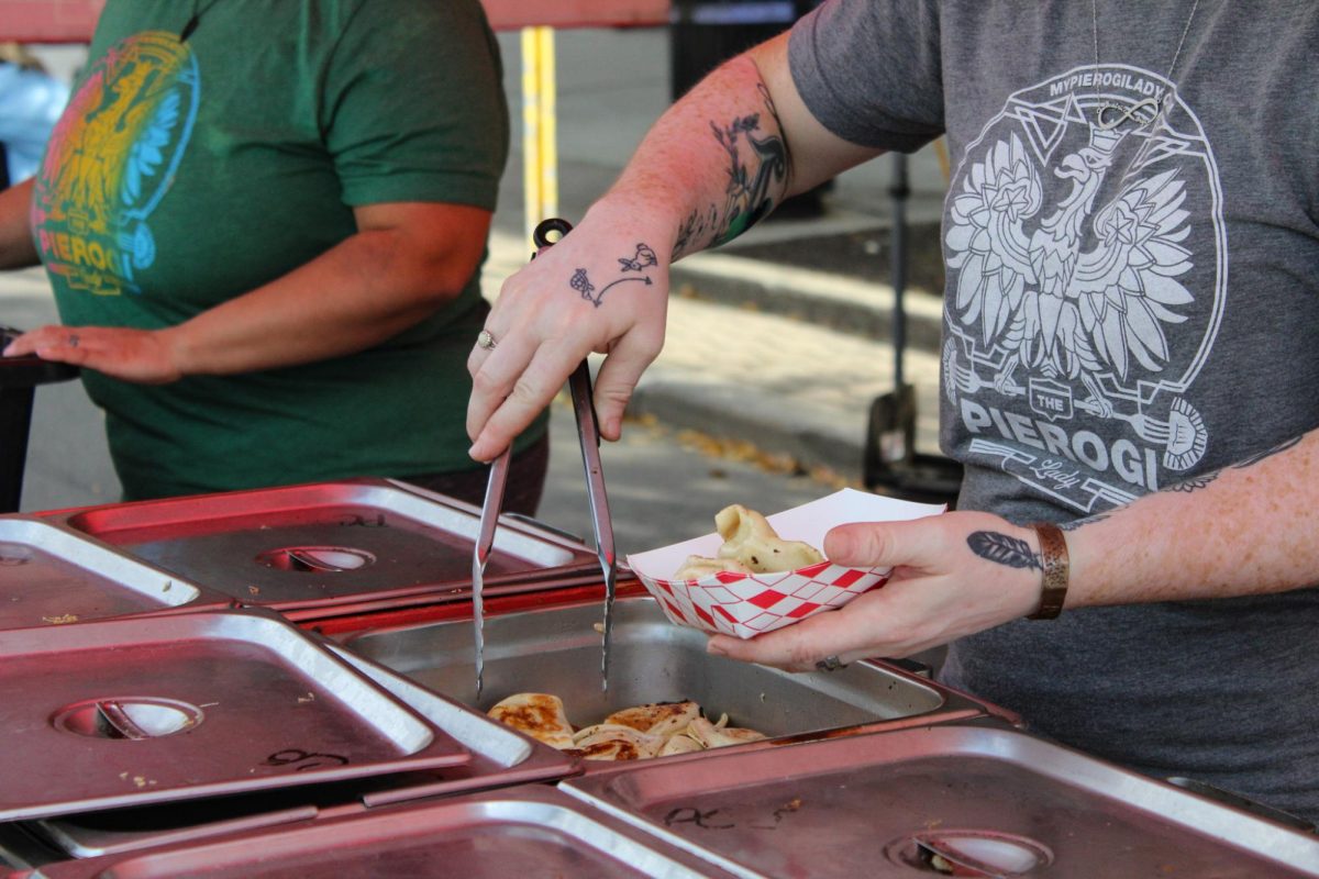 An employee at The Pierogi Lady completes an order of potato and caramelized onion pierogis at Main Street Kent Oktoberfest on Sept. 23, 2023. 