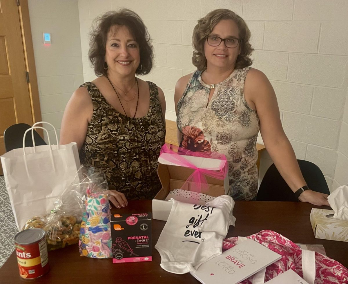 Sandra Austhof and Susan Lettieri show the box they welcome mothers with, including prenatal vitamins, ready-made soup and more. 