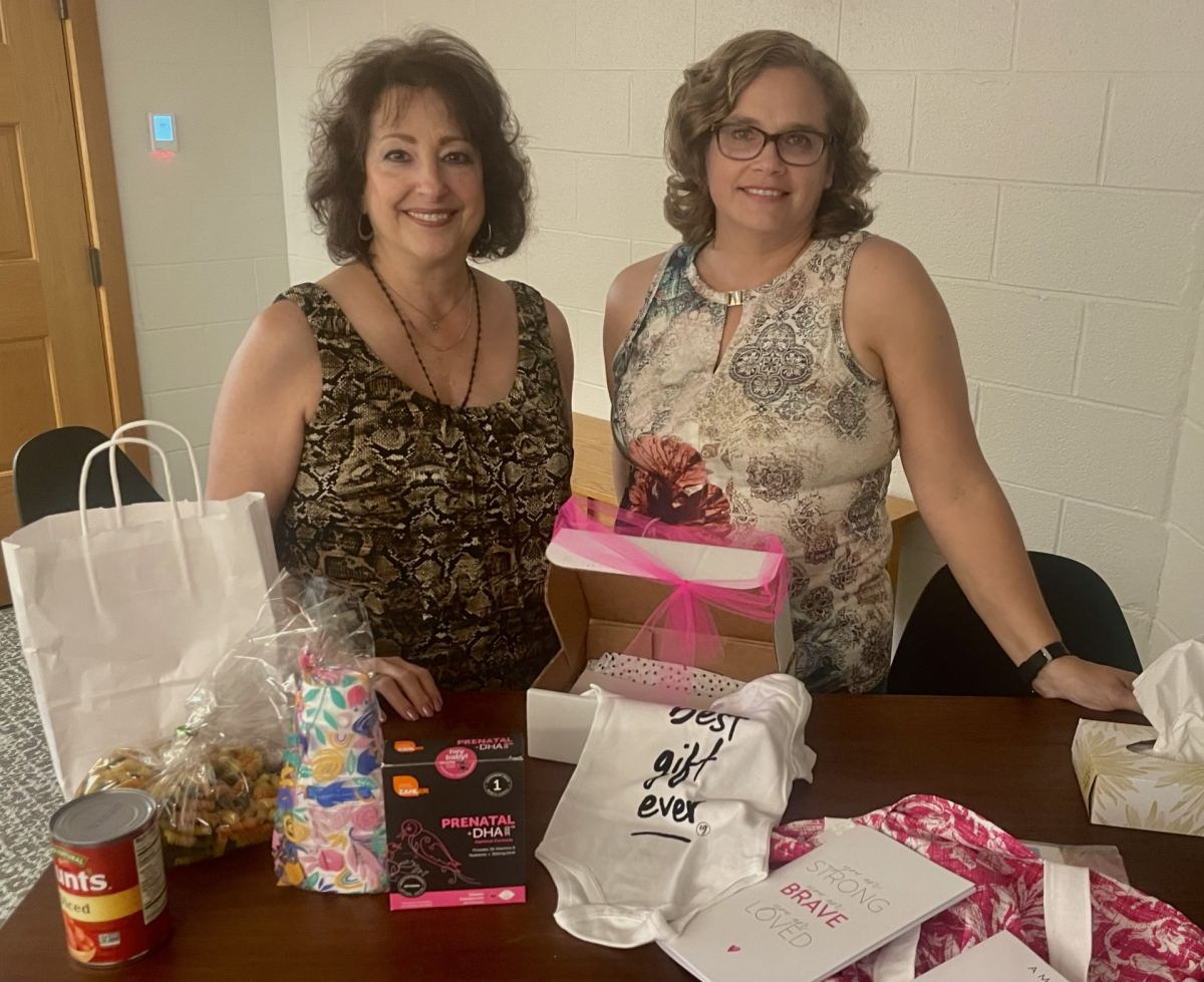 Sandra Austhof and Susan Lettieri show the box they welcome mothers with prenatal vitamins, ready-made soup and more. 