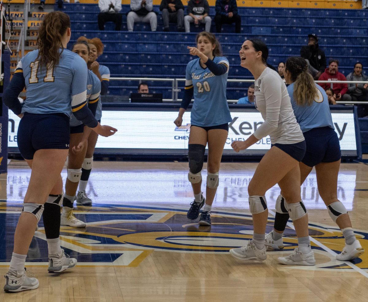 Following a successful kill by sophomore outside hitter Mackenzie McGuire (11), senior Defensive Specialist Bryn Roberts (3 in white) and sophomore setter Kendall White (20) are among the teammates celebrating the point against Central Michigan on Nov. 3, 2023.