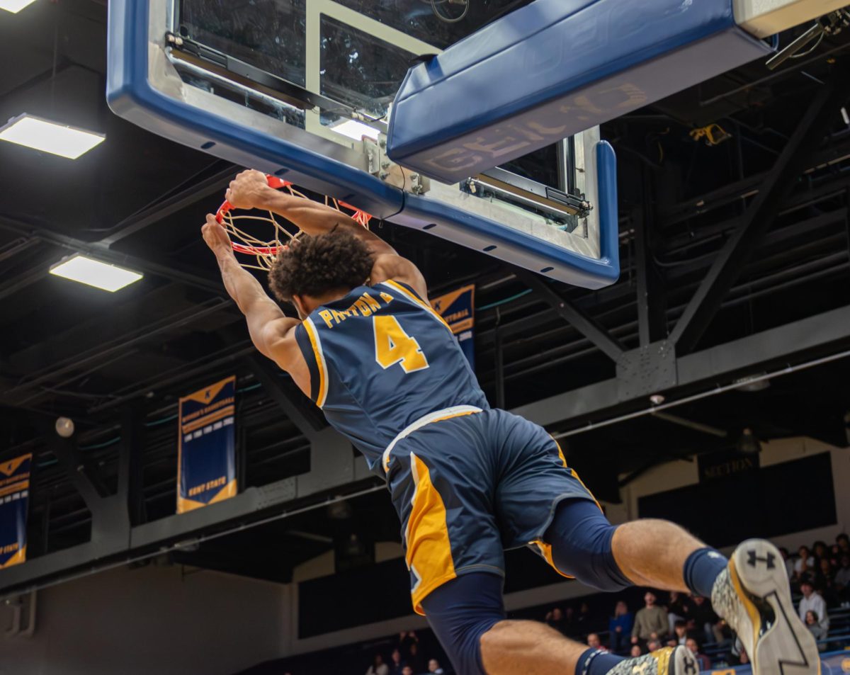 Graduate student Chris Payton Jr. hangs from the hoop after scoring a slam dunk during the game against Fresno State on Nov. 11, 2023.