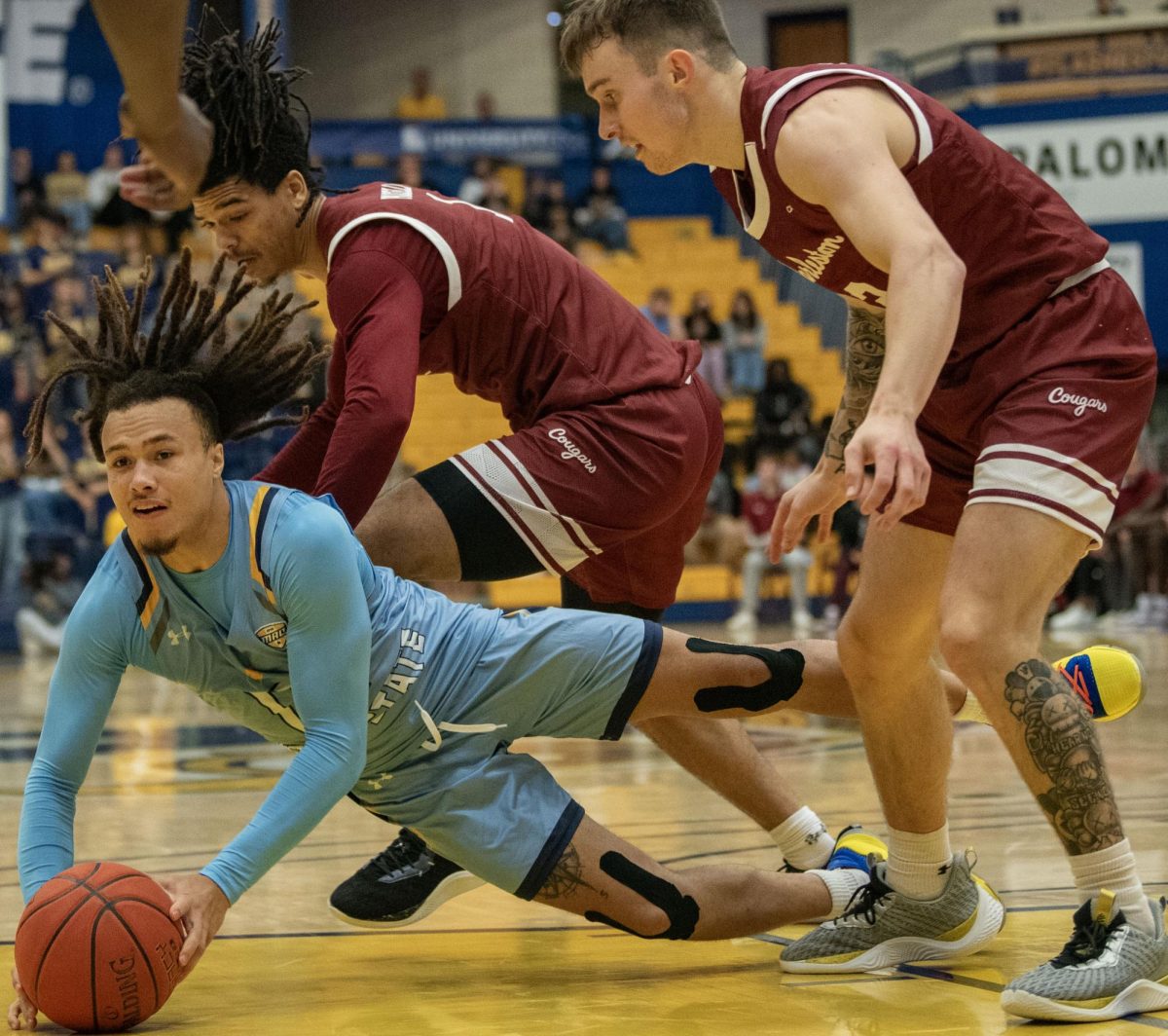 Kent State junior guard Jalen Sullinger dives between Charleston forward Frankie Policelli (left) and guard Reyne Smith to gain possession of a loose ball during their game on Nov. 26, 2023.