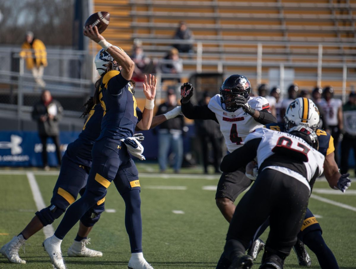 Kent State junior quarterback Devin Kargman attempts a pass under pressure from Northern Illinois defensive end Ray Thomas during the Nov. 25, 2023 game.