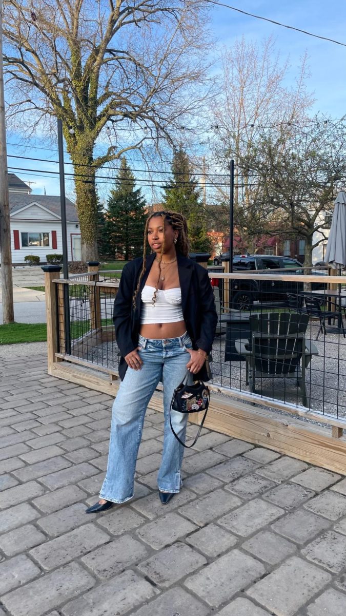 Senior fashion design student Nicole Farmer poses in straight-legged jeans with her black shoulder bag. 