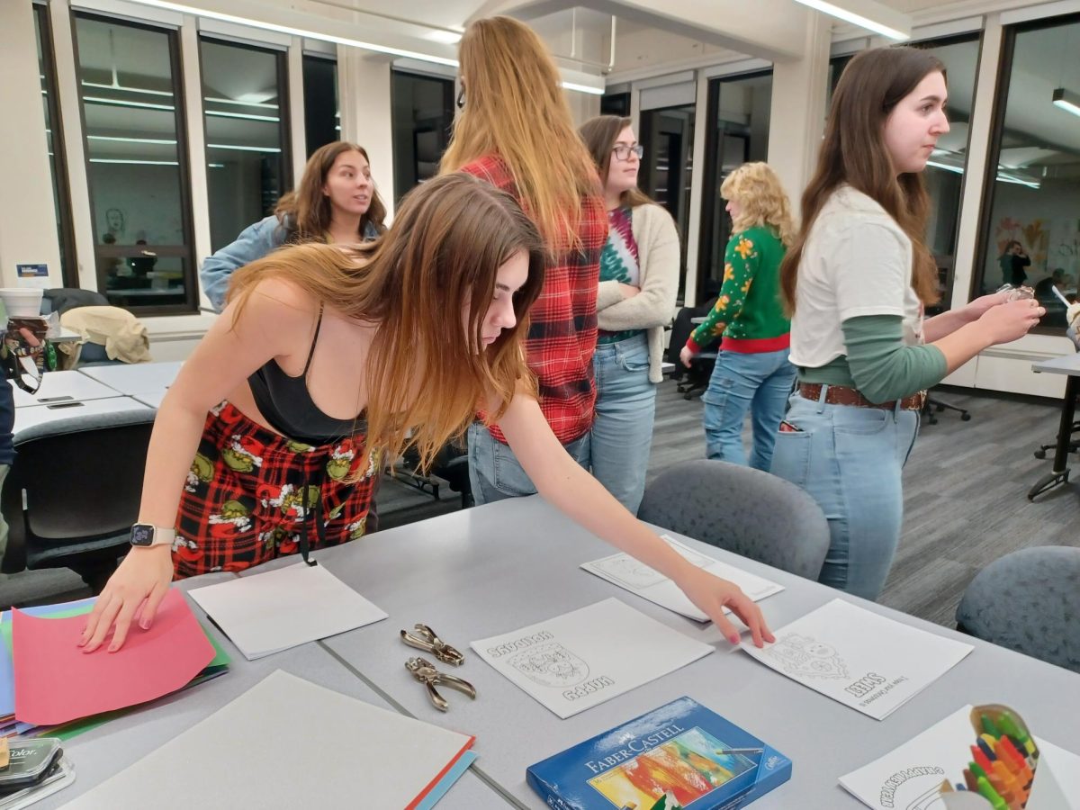 Students grabbing materials to create cards at AIGA design event "Wrap Up The Semester" on Dec. 6, 2023.