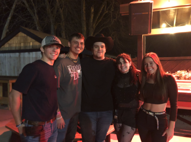 Logan Bennett (center left) and Noah Silvestro (center) stand around the Dusty Armadillo's outdoor patio with friends on Dec. 15, 2023. 