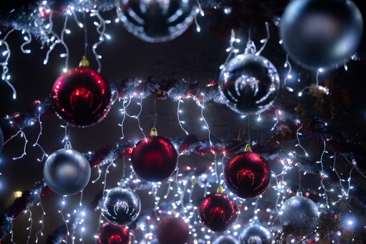 Christmas ornaments are hung up for display in the windows of McKay Bricker Framing's store in Kent, Ohio on Dec. 10, 2023.