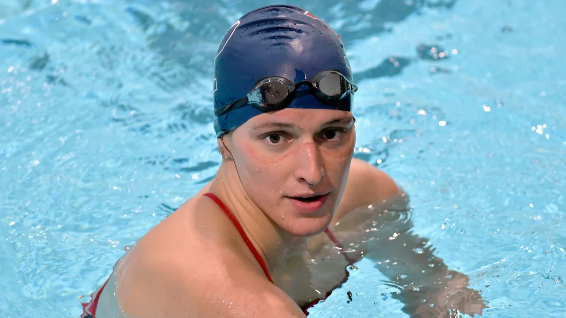 University of Pennsylvania transgender swimmer Lia Thomas speaks to her coach after winning the 500 meter freestyle during an NCAA college swimming meet with Harvard on January 22, 2022.