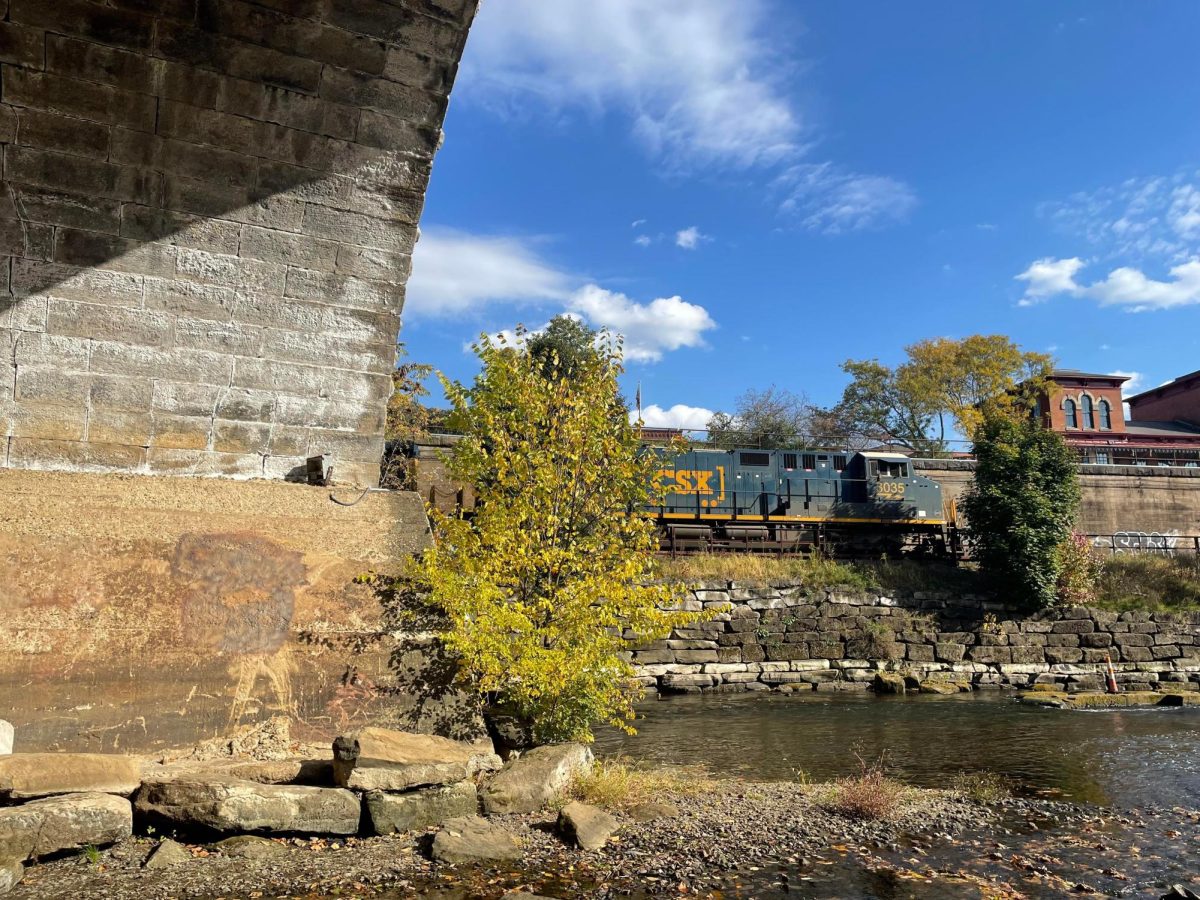 A train passes through downtown Kent from a view underneath the bridge. 