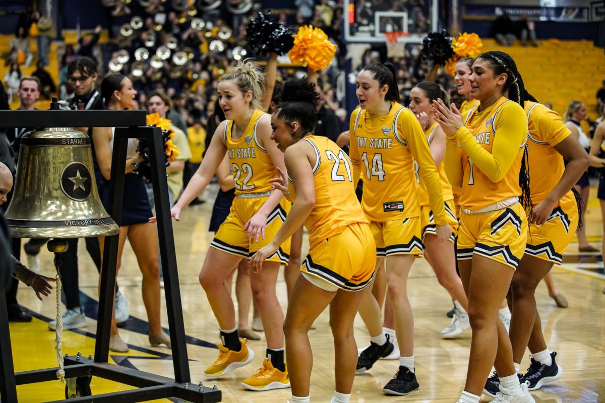 Graduate student guard Abby Ogle (front middle) and her team celebrate their win against Akron by ringing the bell on Feb. 24, 2024.