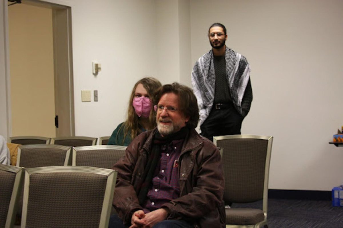 Patrick Gallagher, faculty and associate professor of Spanish at KSU. Behind him, Vivian Schmidt, a computer science student, and Yaseen Shaikh, President of Students for Justice in Palestine, at the SJP's “Let’s talk about Gaza” event on Feb. 15, 2024.