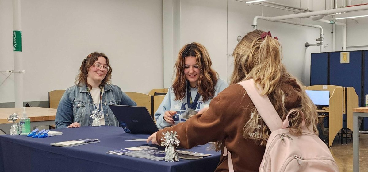 Alexis Osburn and Izzy Niedermier talk with a student for the Student Life Study