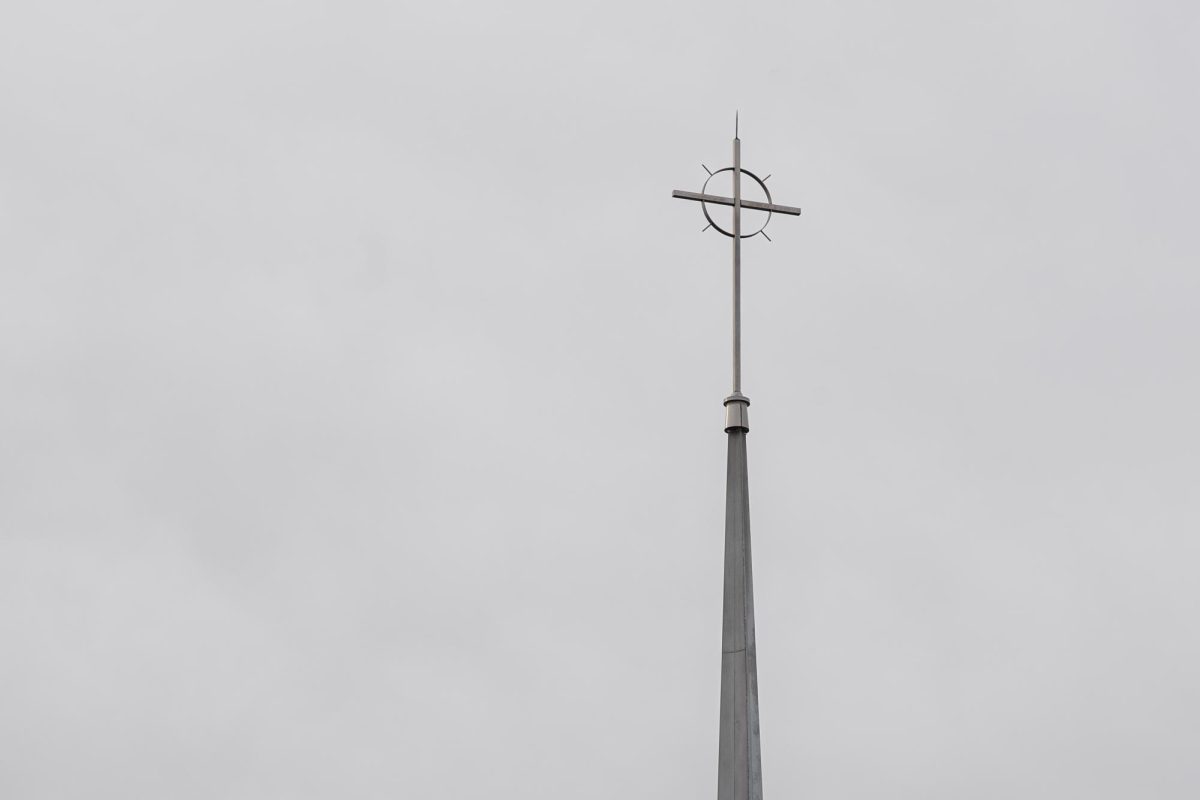 A cross symbolizing Jesus Christ's crucifixion stands atop the steeple of a church in Kent.