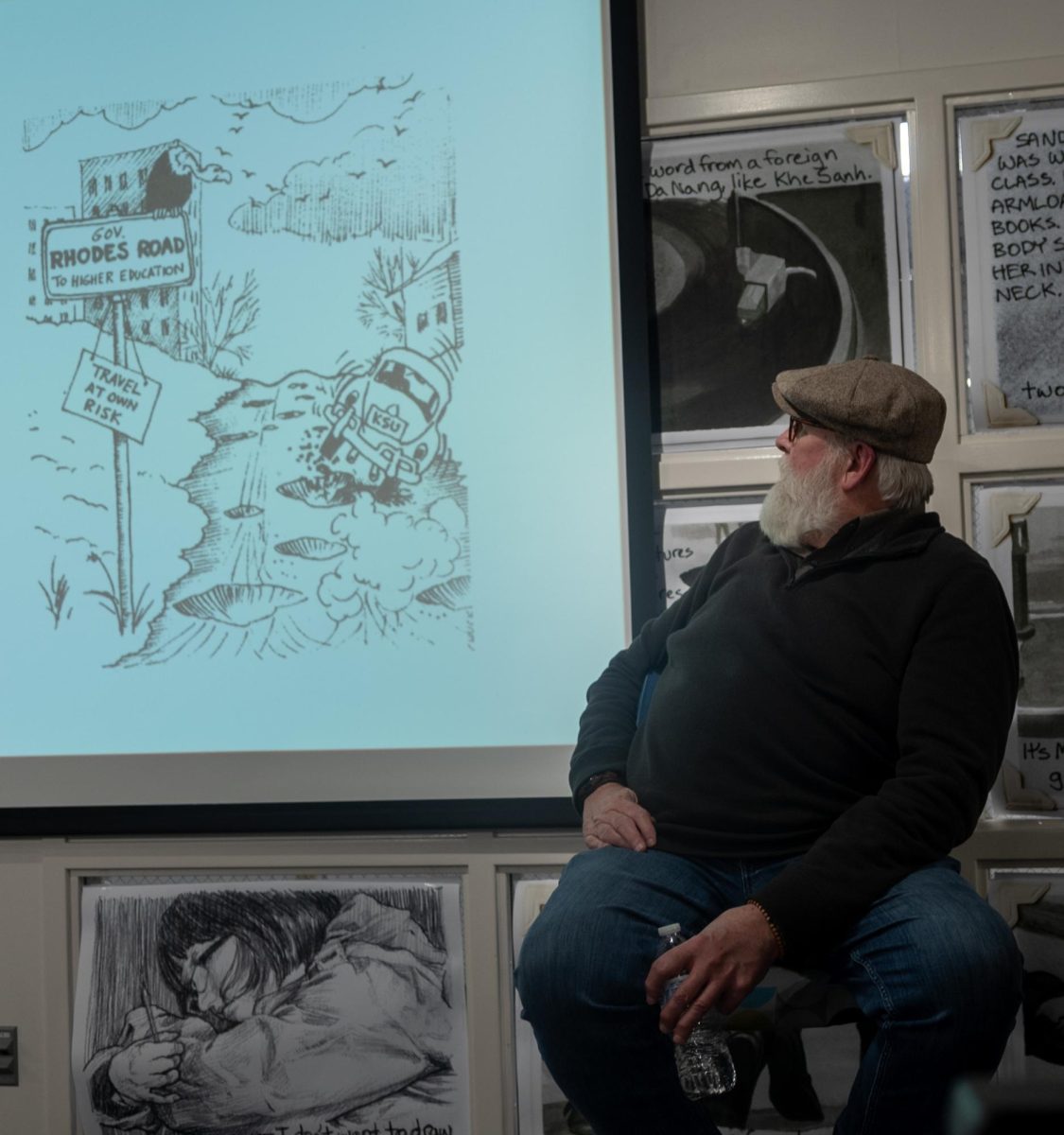 Chuck Ayers discusses one of his political cartoons published in the Daily Kent Stater during the Opening Dialogue series, Graphic Content: Comics of May 4th, at the May 4th Visitor's Center on March 20, 2024.