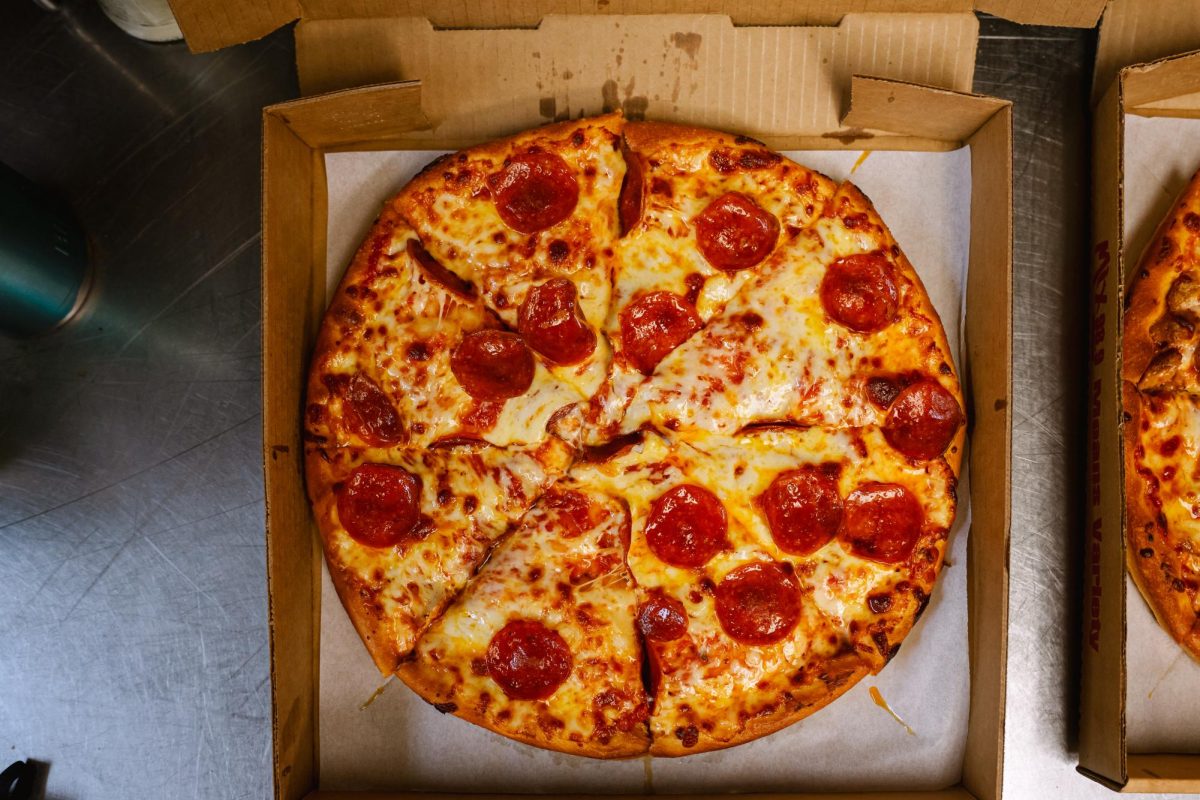 A pizza order from Belleria's is sliced, boxed, and prepared for the costumer.