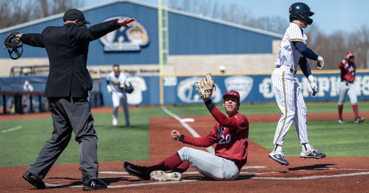 St. Joseph pitcher Luke Gabrysh protests the safe call made by home plate umpire Jeff Clifford following Kent State's Bo Shinkle's game winning run, as Shinkle celebrates the win over the Hawks on March 24, 2024. Manager Jeff Duncan sent in Shinkle to pinch run for Brody Williams after Williams' second walk of the game. 