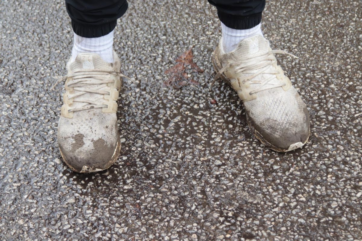 The muddy shoes of Nick Beck, as he and his friends recount that the rain won't stop their good time and how a table was already broken.