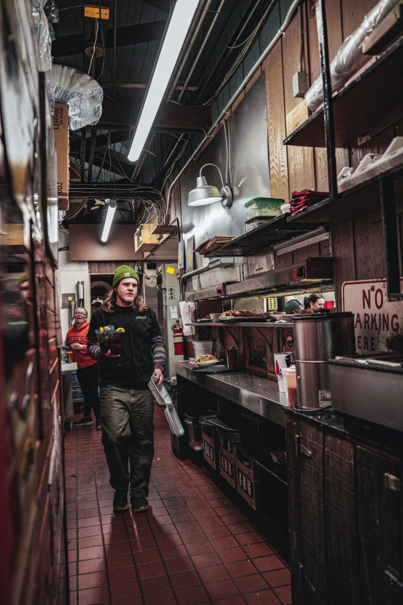 Employees at Mike's Place carry orders through the kitchen.