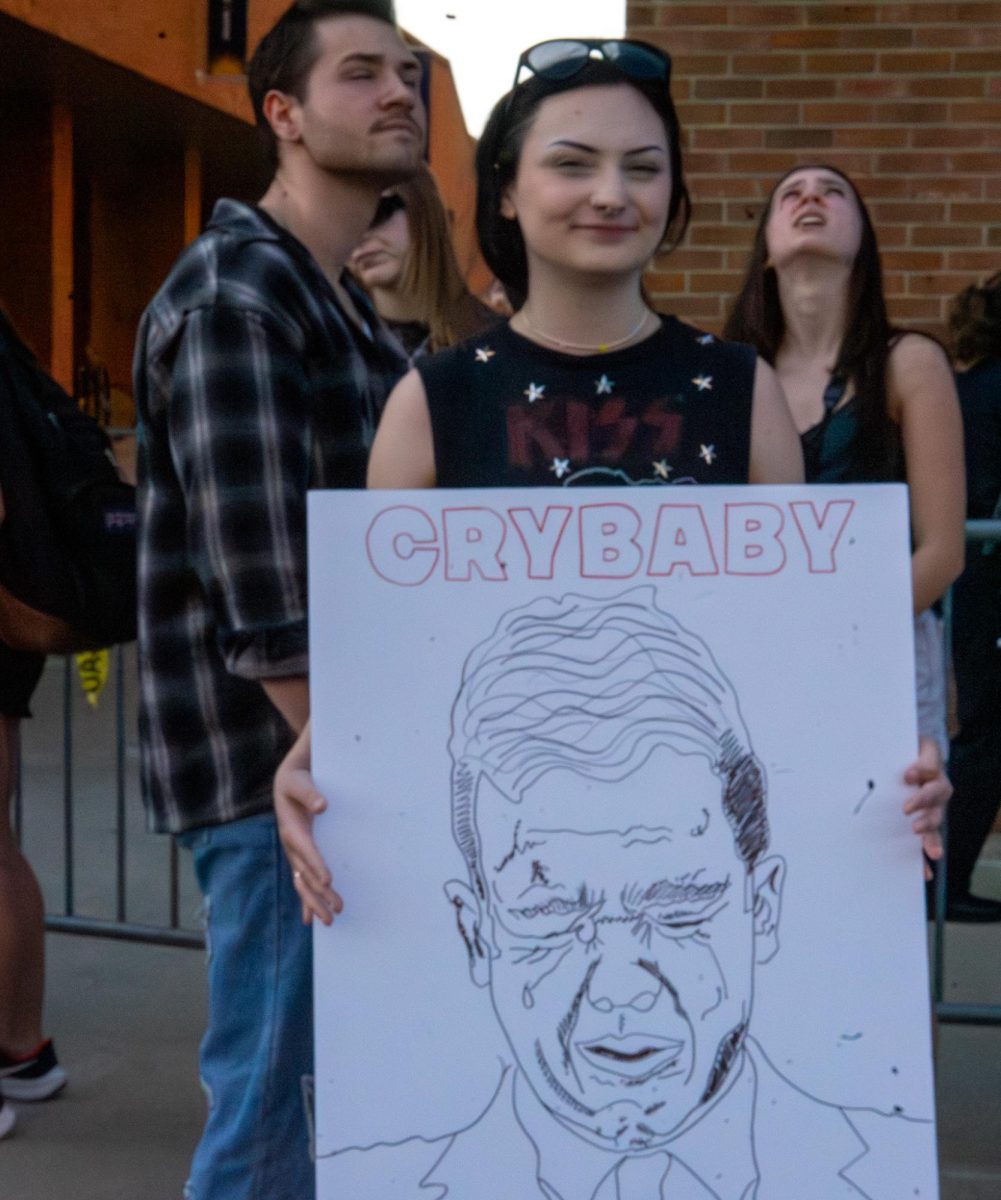 Kent State Tuscarawas student Frankie Alguire shows off her hand made sign to protest Kyle Rittenhouse's appearance and speech at Kent State April 16, 2024. 