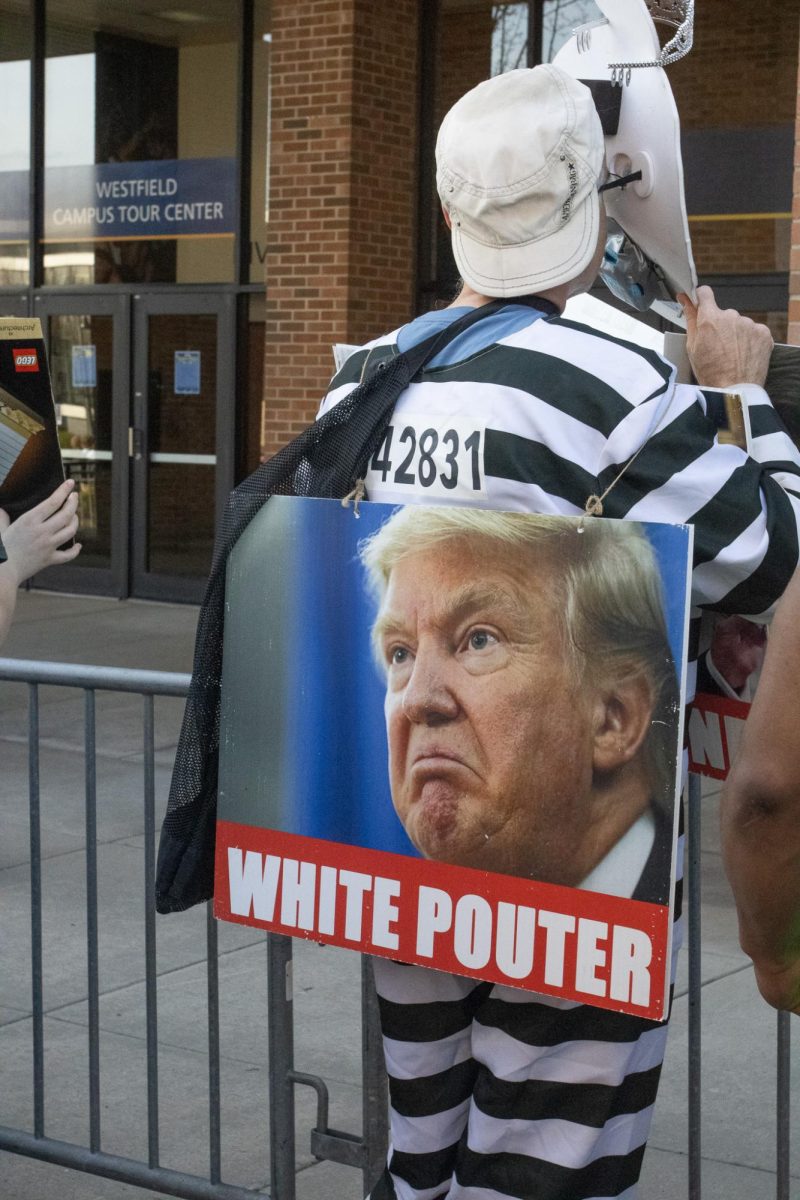 A protestor on Kent State's campus dawns a sign April 16, 2024.