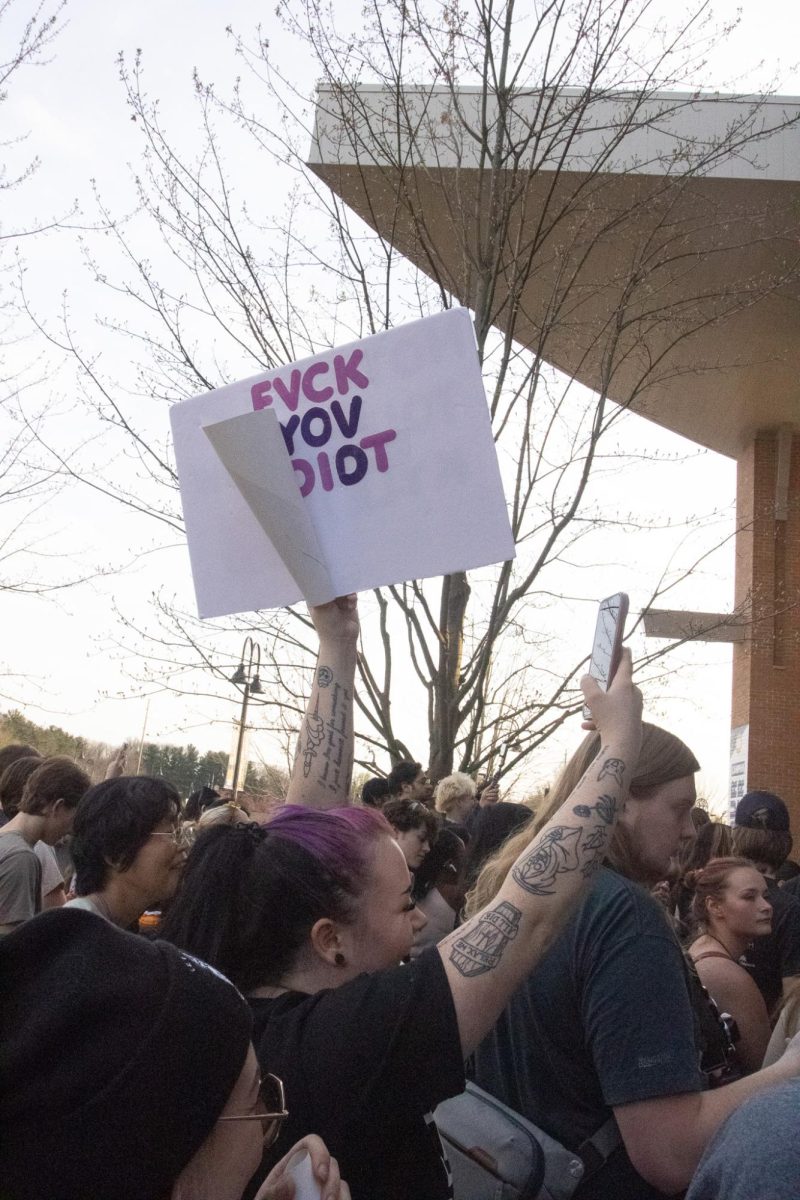 A protestor holds up a sign against Kyle Rittenhouse on April 16, 2024 as attendees of The Rittenhouse Recap leave.