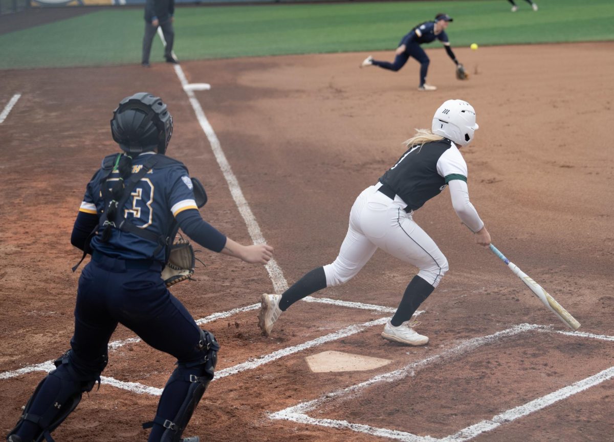 Ohio's Lauren Yuhas pokes a ground ball past graduate student third baseman Alexandria Whitmore in the Golden Flashes 7-1 loss to the Bobcats in Game 1 on April 2, 2024.