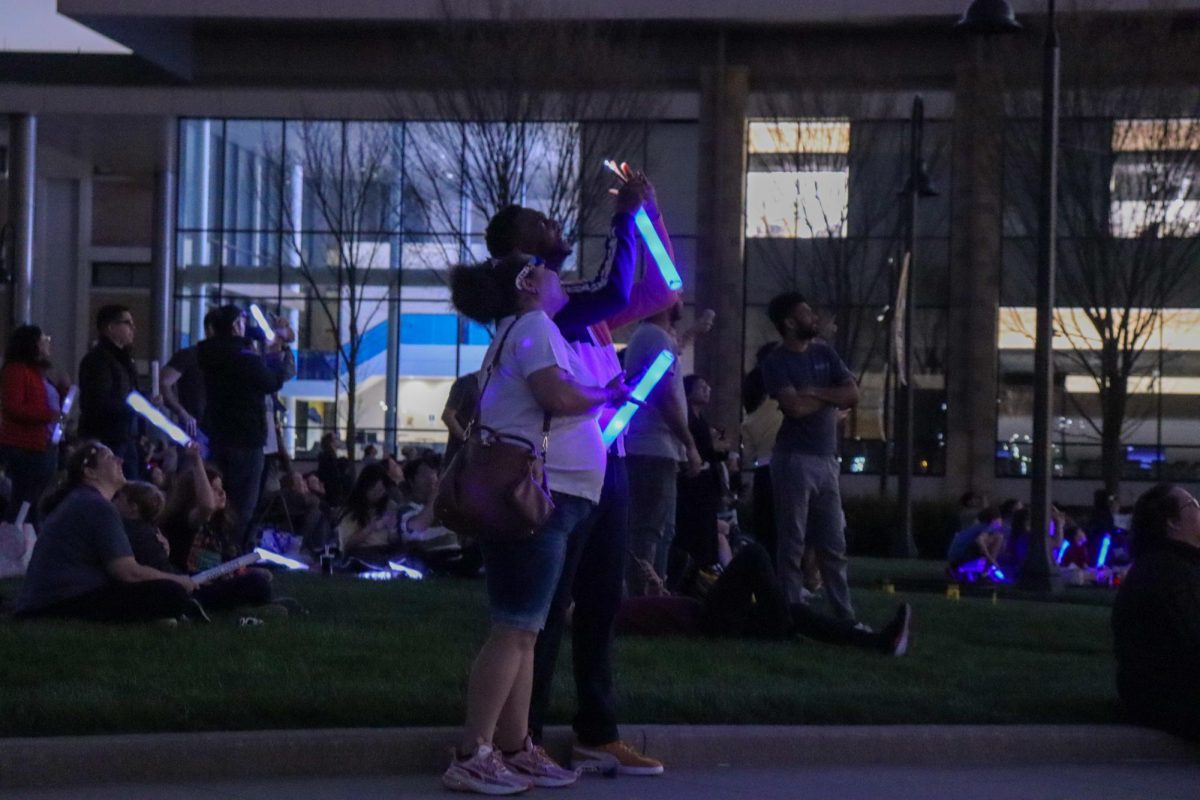 A couple stands together during the totality of the solar eclipse on April 8, 2024.